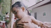 Adorable baby girl taking a bath washing and cleaning by mother with...