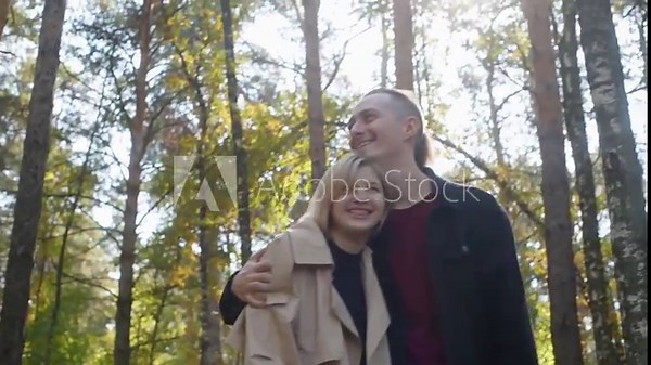 Romantic couple walking together in a forest, enjoying the sunlight filtering through trees, sharing intimate moments of love and connection amidst nature's beauty