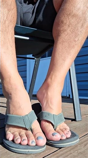 Male pedicured toes with matching flip flops