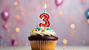Birthday cupcake with lit birthday candle. Number three for three years or third anniversary.
