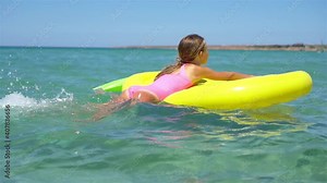 Adorable girl on inflatable air mattress in the sea Stock Video