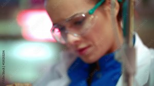 Scientist cure research. Closeup of female scientist mixing chemical liquid in lab flask. Close up of medical scientist working with liquid sample. Woman scientist analyzing chemical reagents