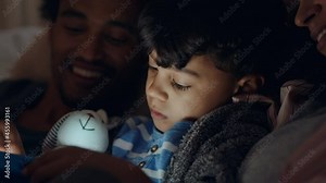 cute little boy using tablet computer happy mother and father watching child playing games on touchscreen technology having fun before bedtime