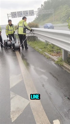 Workers use a wheeled winch cart to lay the steel line across the guardrail. | Gayle’s Smart Ideas