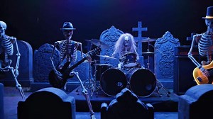 Download Skeletal Band Plays Guitar and Drums in a Graveyard Concert at Night for free
