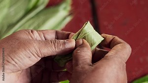 An asian woman prepares ingredients for betel nut chewing also called betel quid chewing or areca nut chewing