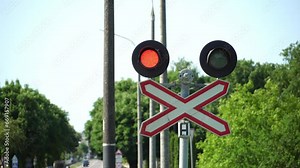 A railway traffic light with a flashing red signal. Railway and automobile crossing. A traffic light with a forbidding signal. Red light. Intersection of a highway with railway tracks