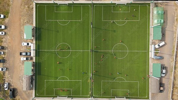 Drone footage aerial view of many people are practicing sports on the artificial grass football field, outdoor field