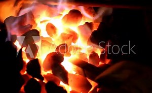 Blacksmith at work, melting iron in a small furnace