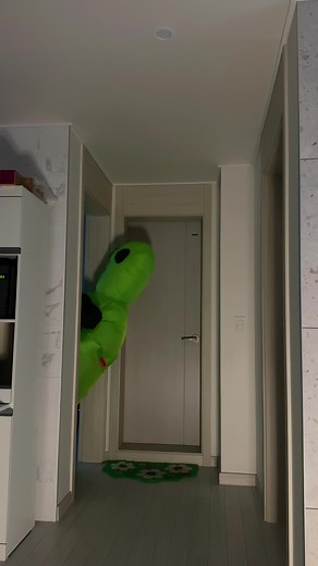 Playful Alien Costume Adventures in Bright Hallway