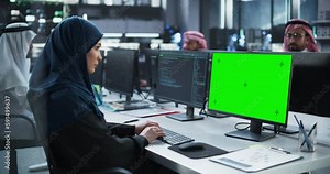 Arab Female Software Developer Working on Desktop Computer with Green Screen Mock Up Display. Young Middle Eastern Specialist Testing Programming Code for an Innovative Big Data Blockchain Project