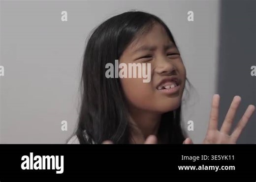 Hysterical little Asian girl crying and looking terrified, panicked child with fearful expression and defensive hand gesture, concept of childhood trauma, bullying, and domestic fear Stock Video Footage - Alamy