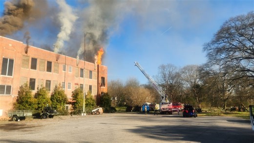 Crews work to put out vacant building fire in Brighton