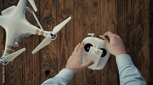 Top view,hands put remote controller on wooden table, mount big smart tablet with chromakey screen and turn on drone in left corner.Leds blink,4k camera with nd filter initialized and ready to work