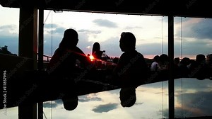 Two young women smoking, drinking at restaurant terrace at sunset, enjoying life Stock Video