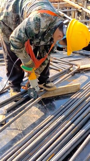 Construction Worker Cutting Reinforcing Steel Bars with an Angle Grinder on Building Site