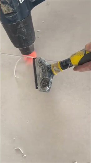 Using heat gun and scraper to remove old floor grout
