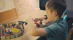 Child boy playing, builds, creating, metallic game toy in his children room in evening time. Stay at home. 4K video. Stock Video