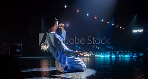 Lead Singer of a Pop Band Performing a Hit Song on Stage, Inspiring a Large Audience of Music Enthusiasts. Musician Performing in Front of Diverse Happy People that are Dancing in the Room