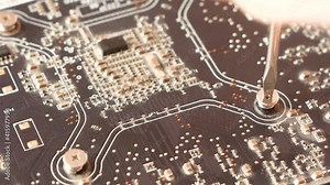 Close up of motherboard repair. A screwdriver disassembles the motherboard when repairing a computer. Defective computer module, repair and refurbishment.Selective focus, shallow depth of field