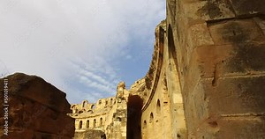 Birds Flying Over El Jem Amphitheater Against Cloudy Sky - El Djem, Tunisia
