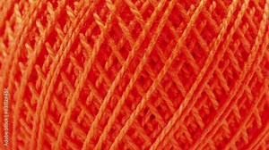 Closeup of the texture of threads on the coil. Texture of threads in a spool of orange color.