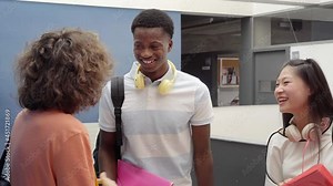 Multicultural classmates talking to each other at break of classes in high school. Friendly young teenagers.