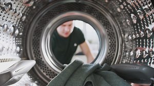 View Looking Out From Inside Washing Machine As Man Puts In Laundry Load | Premium Stock Video Footage