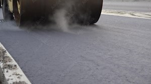 Road rollers are ramming the new asphalt surface on road.