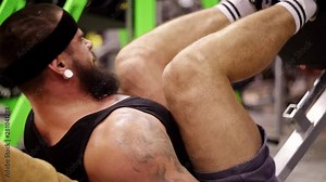 Large powerful man building muscles in the gym