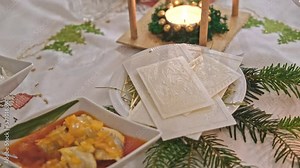Traditional Polish Christmas Eve Dinner Table with White Christmas Wafer Laying on Hay