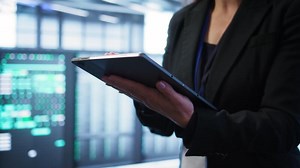 Computer scientist managing data center with advanced technology using digital device. Close up shot of person in server room optimizing data center gear with tablet, camera B