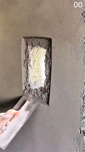 Hand positions white block inside plaster wall opening