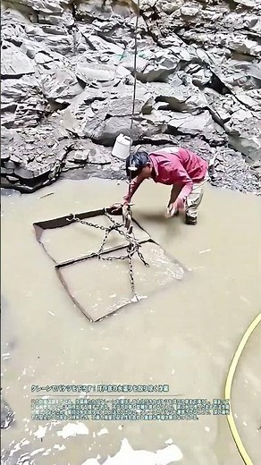 クレーンでバケツを下ろす：井戸底の水溜りを取り除く作業