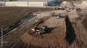 As a dump truck readies to drop a load of soil, a Multi Terrain Loader pushes and spreads the soil out. Stock Video