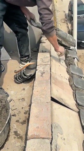 Mason applying mortar to install traditional roof tiles