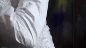 Scientist wears a protective suit. Clip. Person in a laboratory wearing a biohazard suit while working with hazardous toxic material