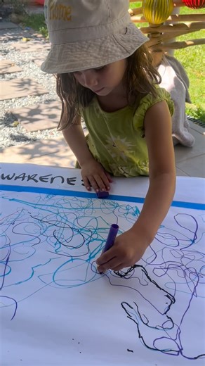 ✨ Collaborative Art Experience ✨ This week, the kids are invited to take part in a beautifully simple yet powerful collaborative art activity. A large sheet of paper has been set up with a bold blue border, and in the centre we placed four golden stones and four colourful pens. Each child selected a pen and used it to gently push their golden stone around the paper, staying carefully within the blue lines. As the stones travelled, they created unique pathways and shared creative space with their