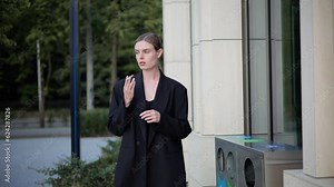 A stylishly dressed businesswoman holds a cigarette in her hand, wanting to get rid of the harmful habit. Woman girl breaks it in half and throws it in the trash. Say no to tobacco and smoking.