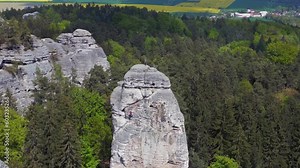 Climber on the cliff mary rock view nature hills mountains bohemian paradise. Wonderful aerial top view flight czech republic spring 2023. descending drone 4k uhd cinematic footage.