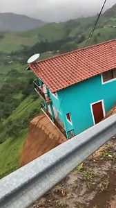 House Vanishes in Violent Landslide Antioquia, Colombia — May 18, 2024 A mountainside home was swallowed whole by a catastrophic landslide Saturday afternoon following days of relentless rainfall that saturated the steep terrain. The terrifying moment was captured on video by onlookers who had stopped on a nearby road, showing the structure completely vanishing down a ravine in a matter of seconds. The dramatic footage shows a vibrant turquoise house perched perilously on the edge of a crumbling
