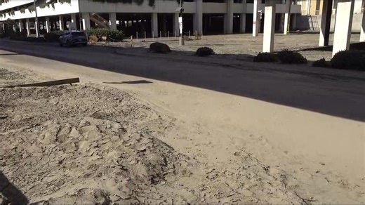 Road to Fashion Valley Mall covered in dirt and debris, weeks after flooding