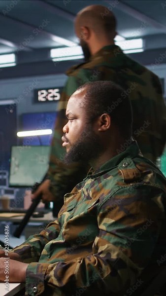 Vertical video Military officer making telephone call to relay enemy info gained using tracking equipment. Army specialist talking on phone, giving intel helping troops, coordinating mission