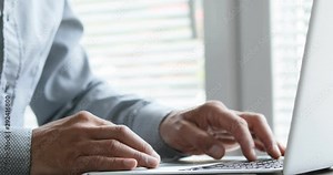 man typing at his laptop computer