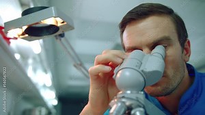 Male doctor microscope. Close up of doctor scientist looking through microscope. Lab worker looking medical microscope. Microscope man face. Clinician doing laboratory research in lab