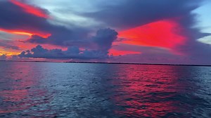 Sunset clip in the Florida Keys, USA, revealing the clouds and red colored sky over the calm ocean | Premium Stock Video Footage