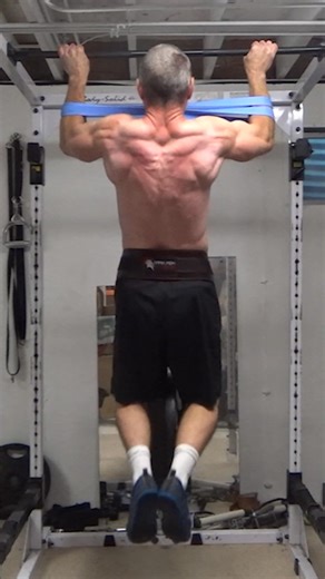 Band-Cuff Pull-Ups...this is one you need to dig into the biomechanics of the lats a bit to understand why it works (it LOOKS like it shouldn't). Or you can just try it and see how it feels! All you need is a 42" band - fold it half and put your forearms through the ends. Grip one hand onto the bar, stretch the band, then grip the other hand on. Now...the rationale for looping the band around the forearms is isometric shoulder adduction tension while doing a pull-up. At the bottom of the pull-up