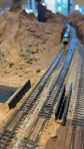 A custom Apache Railway locomotive pulls a wind turbine train along the Sun N Sand N Scale model train layout. #train #modeltrains #nscalemodeltrains #trains #railroad #customtrains #nscale #windturbine #modelrailwayscene #facebookviral #reelschallenge #metaverse | Garret Hauser