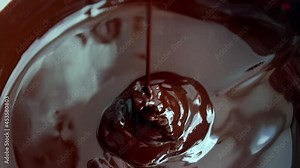 Delicious brown chocolate pouring down with swirl. Delicious chocolate flowing down. Confectionery concept. Sweet food
