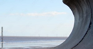 Ingoldmells, Skegness beach framed by sea defences on a cold winters day with wind turbines in the distance